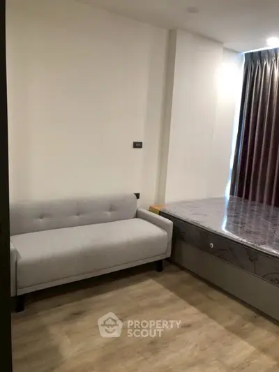 Modern bedroom with stylish sofa and elegant curtains
