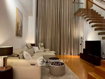 Luxurious modern living room with elegant staircase and plush seating