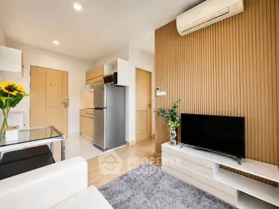 Modern living room with open kitchen, sleek design, and cozy ambiance in a stylish apartment.