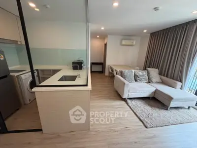 Modern open-plan living room with kitchen, featuring cozy sofa and dining area, perfect for urban living.