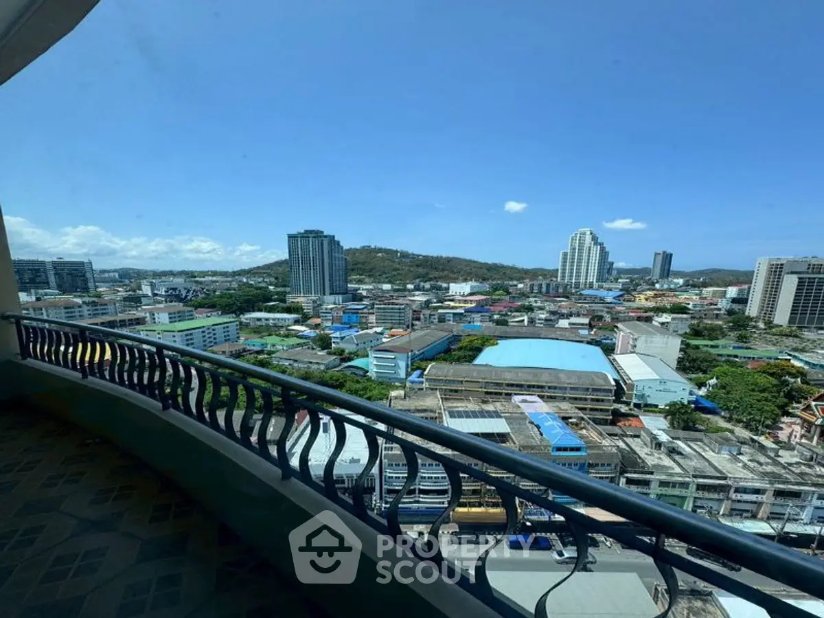 Stunning cityscape view from a high-rise balcony, showcasing urban skyline and blue skies.