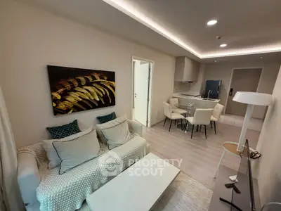 Modern living room with cozy seating and elegant dining area in open layout apartment.