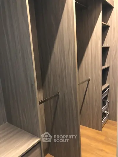 Spacious walk-in closet with modern wooden shelving and ample storage space.