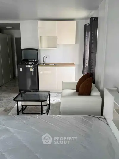 Modern studio apartment with compact kitchen and cozy living area, ideal for urban living.