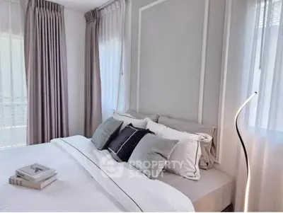 Elegant bedroom with modern decor and soft lighting, featuring plush pillows and stylish curtains.