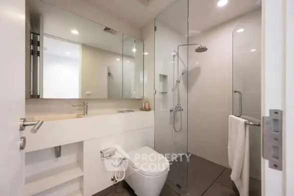 Modern bathroom with glass shower and sleek fixtures in a contemporary home.