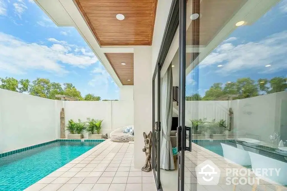 Luxurious private poolside patio with modern design and lush greenery