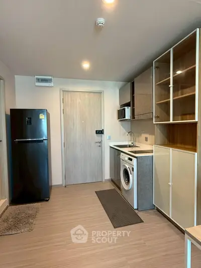 Modern kitchen with sleek appliances and ample storage in a stylish apartment.