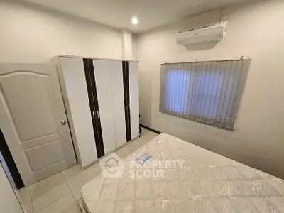 Cozy bedroom with air conditioning and wardrobe, perfect for a comfortable living experience.