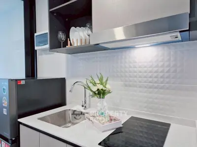 Modern kitchen with sleek design, featuring induction cooktop and stylish backsplash.