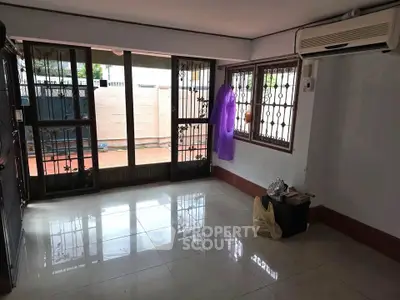 Spacious living room with large windows and air conditioning, perfect for natural light.