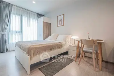 Modern bedroom with cozy decor and natural light, featuring a stylish bed and dining area.