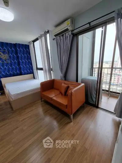 Modern bedroom with balcony, featuring a cozy sofa and stylish decor.