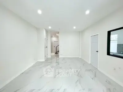Spacious modern interior with marble flooring and bright lighting, ideal for versatile living space.