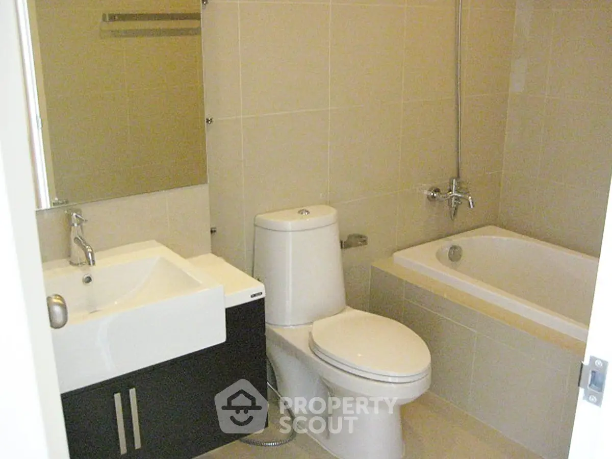 Modern bathroom with sleek fixtures and a bathtub in a contemporary apartment.