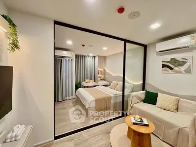 Modern studio apartment with glass partition, cozy living area, and stylish bedroom.