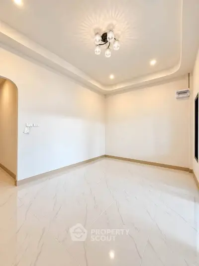 Spacious empty room with elegant lighting and glossy tiled flooring, perfect for customization.