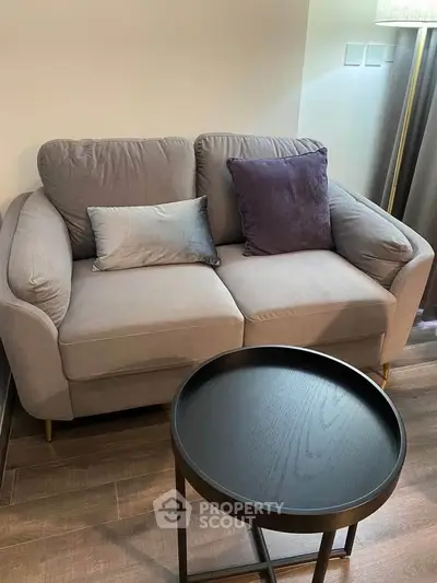 Cozy living room with stylish sofa and modern round coffee table, perfect for relaxation.