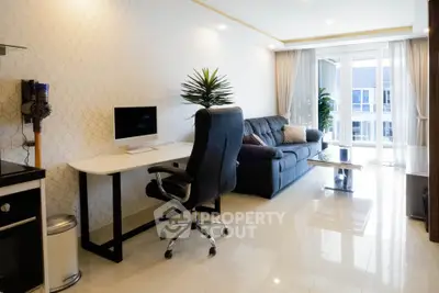 Modern living room with sleek furniture and large windows offering natural light.