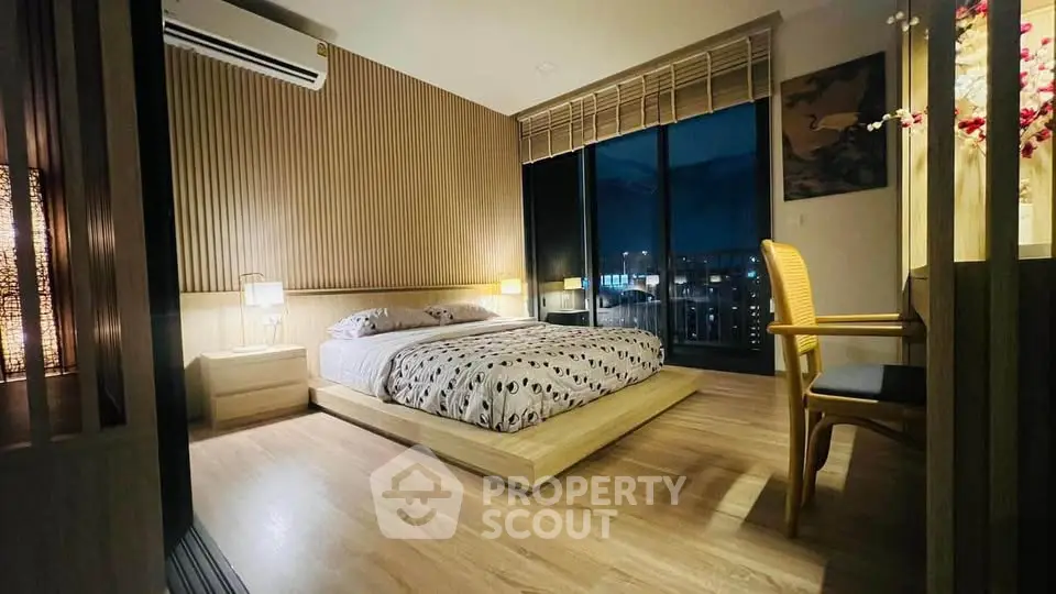 Luxurious modern bedroom with city view, featuring elegant wooden flooring and stylish decor.