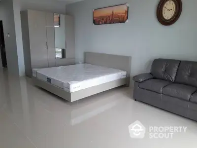 Spacious bedroom with modern furniture and sleek tiled flooring