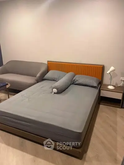 Modern bedroom with stylish bed and cozy sofa in a contemporary apartment.