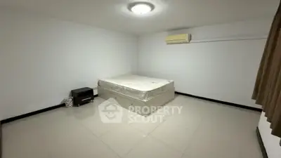 Spacious minimalist bedroom with air conditioning and tiled flooring