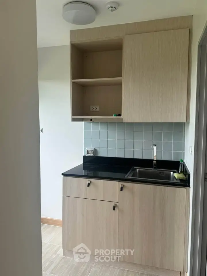 Modern compact kitchen with sleek cabinetry and black countertop