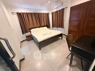 Cozy bedroom with modern furnishings and ample natural light, featuring a comfortable bed and stylish curtains.
