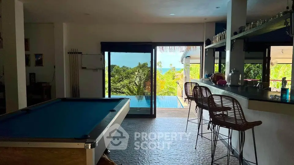 Luxurious open-plan living area with pool table and ocean view, perfect for entertainment and relaxation.