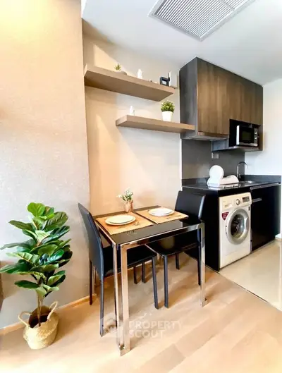 Modern kitchen with dining area and washing machine in stylish apartment