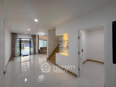 Spacious modern living room with elegant staircase and natural light