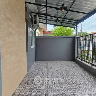 Spacious covered balcony with patterned tile flooring and modern design.