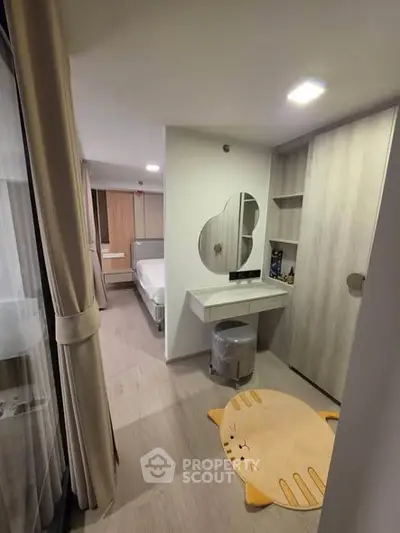 Cozy bedroom with modern decor and unique cat-shaped rug, featuring a stylish vanity and ample storage space.