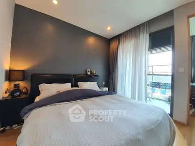 Modern bedroom with cozy bedding and balcony view
