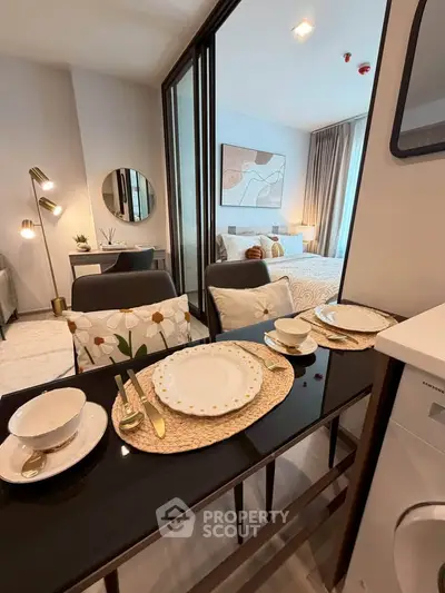 Stylish modern studio apartment with elegant dining setup and cozy bedroom area.