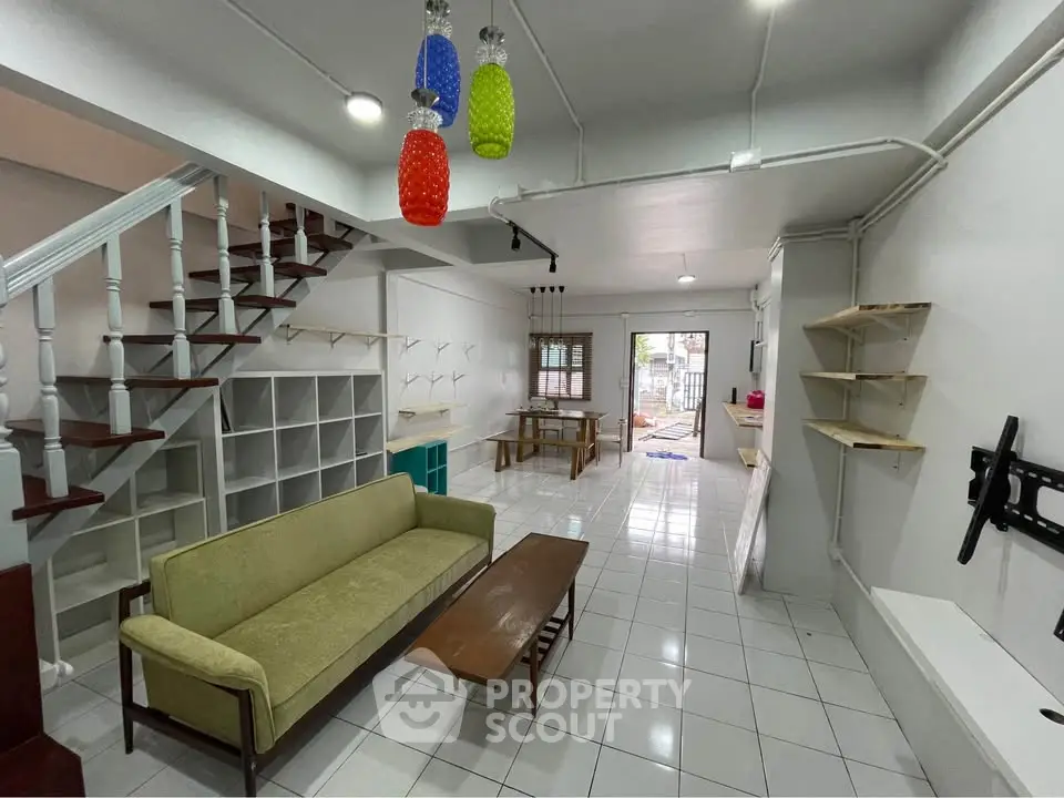 Spacious living room with modern decor and staircase, perfect for family gatherings.
