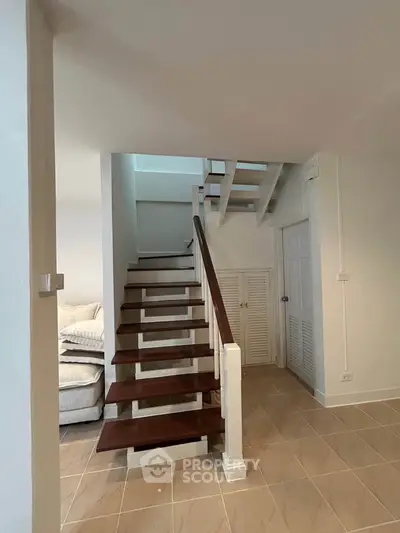 Charming interior with modern staircase and cozy living area, perfect for stylish urban living.