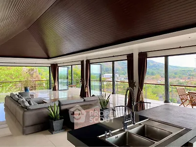 Spacious open-plan living room with stunning panoramic views and modern furnishings.