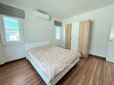 Spacious bedroom with modern design and ample natural light, featuring a large bed and stylish wardrobe.