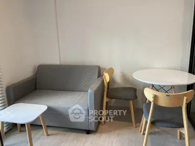 Cozy living room with modern gray sofa and minimalist dining set