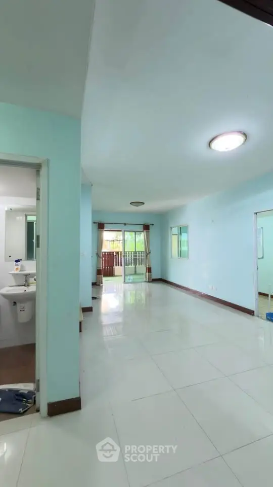 Spacious open-plan living area with large windows and balcony access, perfect for natural light and fresh air.