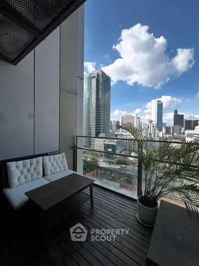 Stunning city view from a modern balcony with cozy seating area.