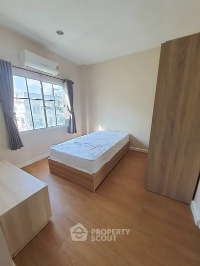 Cozy bedroom with wooden flooring and natural light
