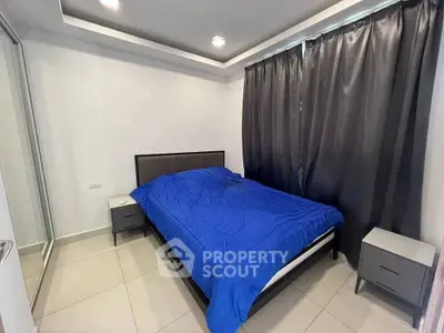 Modern bedroom with blue bedding and sleek furniture, perfect for a cozy retreat.