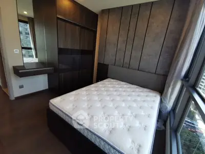 Modern bedroom with large windows and stylish dark wood accents in urban apartment.