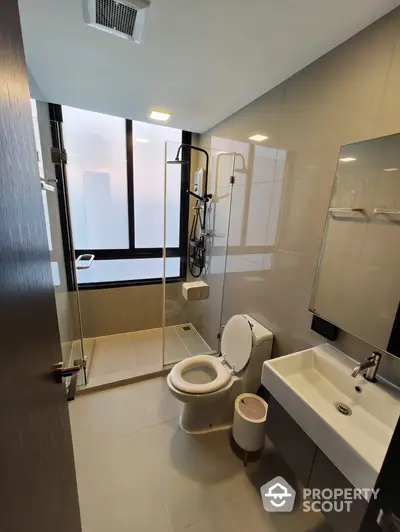 Modern bathroom with glass shower and sleek fixtures in high-rise apartment