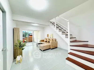 Spacious modern living room with staircase and balcony access, perfect for family gatherings.