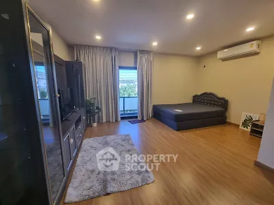 Spacious bedroom with modern furnishings and large window view