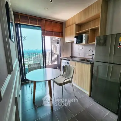 Modern kitchen with city view, featuring sleek appliances and cozy dining area.